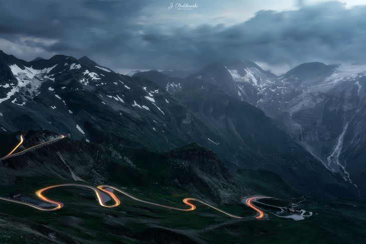 Fotografia, na której widoczne są światła przejeżdżającego samochodu na drodze Grossglockner Hochalpenstraße w Austrii nie chciała wyjść tak jak to sobie zaplanowałem. Musiałem wziąć sprawy w swoje ręce - ustawiłem aparat, wsiadłem do samochodu i jeździłem tak aby powstałe linie idealnie współgrały z wytyczoną drogą.