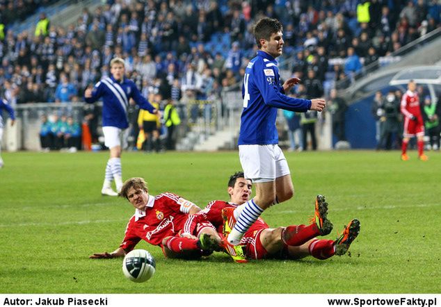 Semir Stilić w meczu z Wisłą Kraków - u jego stóp Cezary Wilk i Gordan Bunoza