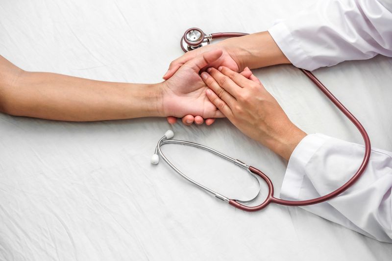 Hand of doctor reassuring her female patient