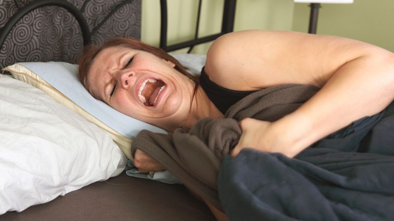 kobieta w łóżku krzyczy
