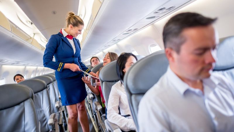 stewardesa rozmawia z pasażerką w samolocie