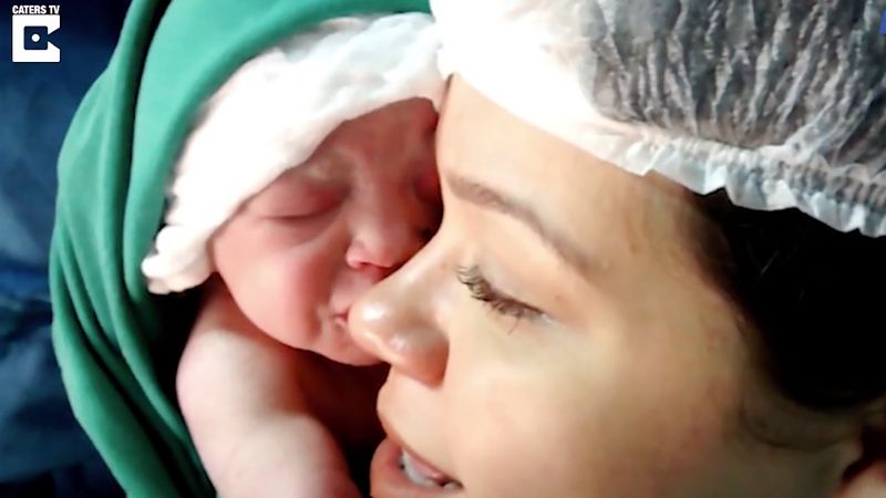 Położna po porodzie przykłada noworodka do twarzy mamy. To, co robi maluszek, rozśmiesza i wzrusza