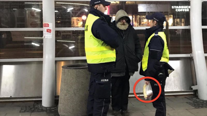 Policjanci podchodzą do bezdomnego. Nie wlepiają mu mandatu, lecz wręczają ten worek