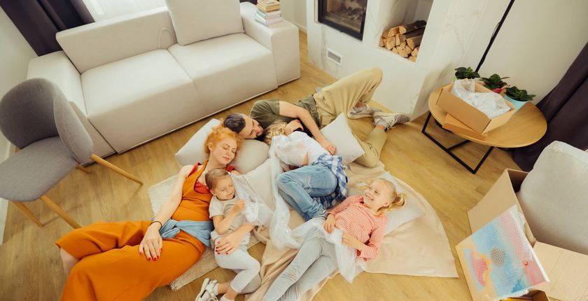 szczesliwa rodzina lezy razem na podlodze w jasnym salonie