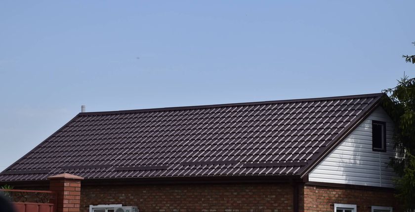 Dach domu pokryty blachą trapezową w brązowym kolorze