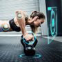 Zdjęcie [url=http://www.shutterstock.com/pic-352080290/stock-photo-muscular-woman-doing-pushups-with-kettlebells-against-fitness-interface.html?language=pl&src=B9I6PnqkodL-y5fuiHnLgg-3-10]ćwiczącej kobiety[/url] pochodzi z serwisu Shutterstock