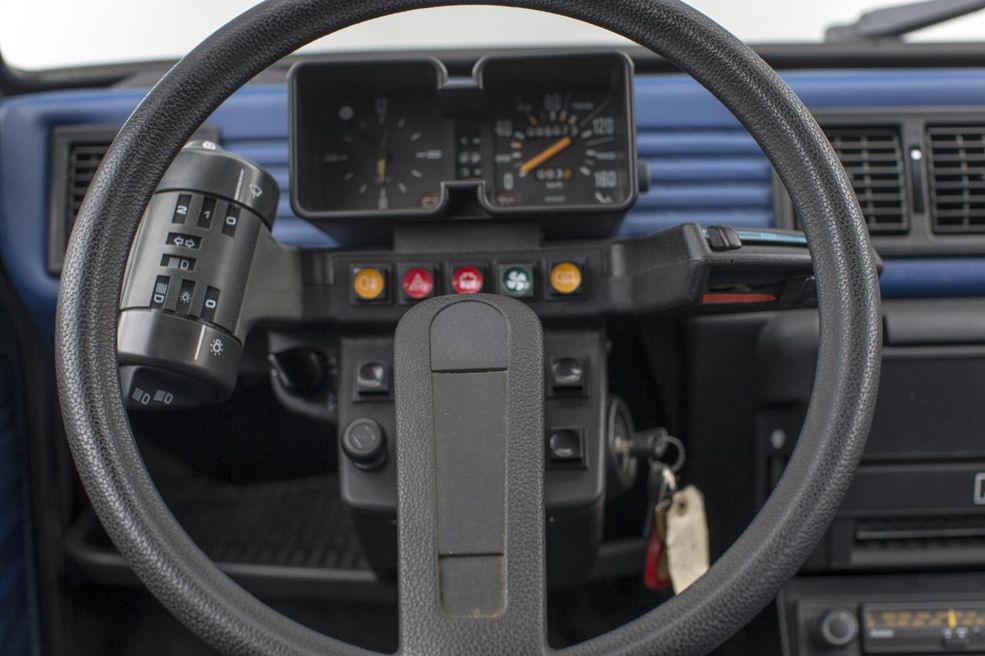 Citroën Visa
Zejdźmy jednak trochę na ziemię. Z pewnością przyznacie, że jeśli przyszłoby wskazać producenta, który robił najbardziej odjechane deski rozdzielcze, to Citroën byłby w czołówce. Nie inaczej było w małej Visie. Chociaż nie otrzymała hydropneumatycznego zawieszenia, to odznaczała się kwadratową obudową zegarów czy charakterystycznymi satelitami przy kierownicy.
Lewą obsługiwało się kierunkowskazy, światła, wycieraczki oraz klakson, natomiast z prawej strony zamontowano suwaki regulujące temperaturę. Taki układ umożliwiał rzekomo obsługę wszystkich urządzeń bez odrywania rąk od kierownicy, jednak wymagało to przyzwyczajenia i odpowiedniej wprawy. Kilka przycisków umieszczono też za kierownicą, tak, że trzeba było sięgać przez wieniec. W 1984 r. zrezygnowano z tego rozwiązania, na rzecz "zwykłych" przełączników i zegarów.