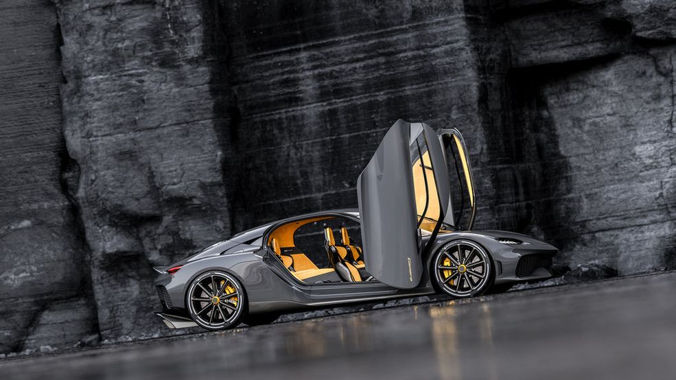 Koenigsegg Gemera
Kompletując wszystkie rozwiązania użyte przez Szwedów przy budowie Gemery, można ją określić jako jedno z najbardziej imponujących aut ostatnich lat. 3-cylindrowy silnik bez klasycznego wałka rozrządu (zasadzie działania konstrukcji przyjrzał się bliżej Marcin Łobodziński) we współpracy z 3 silnikami elektrycznymi (o łącznej mocy 1726 KM), jest w stanie rozpędzić 4-osobową, skandynawską puszkę z włókna węglowego do 400 km/h.
Jeśli obawiacie się, jak będziecie wozić nim dzieci – na tylnych siedzeniach znajdują się uchwyty ISOFIX. A o odpowiednią temperaturę butelki z mlekiem zadbają chłodzące i grzejące wgłębienia. Lepiej jednak nie testować osiągów w porze karmienia, ponieważ konieczna może być wizyta w zakładzie detailingowym (od 0 do 100 km/h auto rozpędza się w 1,9 sekundy). Za to otwieranymi drzwiami wielkości małego lotniska wywołacie niemałe poruszenie pod każdą placówką edukacyjną. A to wszystko za jedyne 1,7 mln dol. (ok. 6,7 mln zł).
