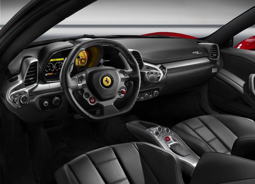Ferrari 458 Italia Zasiadając za sterami tej czerwonej włoszki mamy wrażenie, że deska rozdzielcza za chwile rzuci się na nas we wściekłym ataku