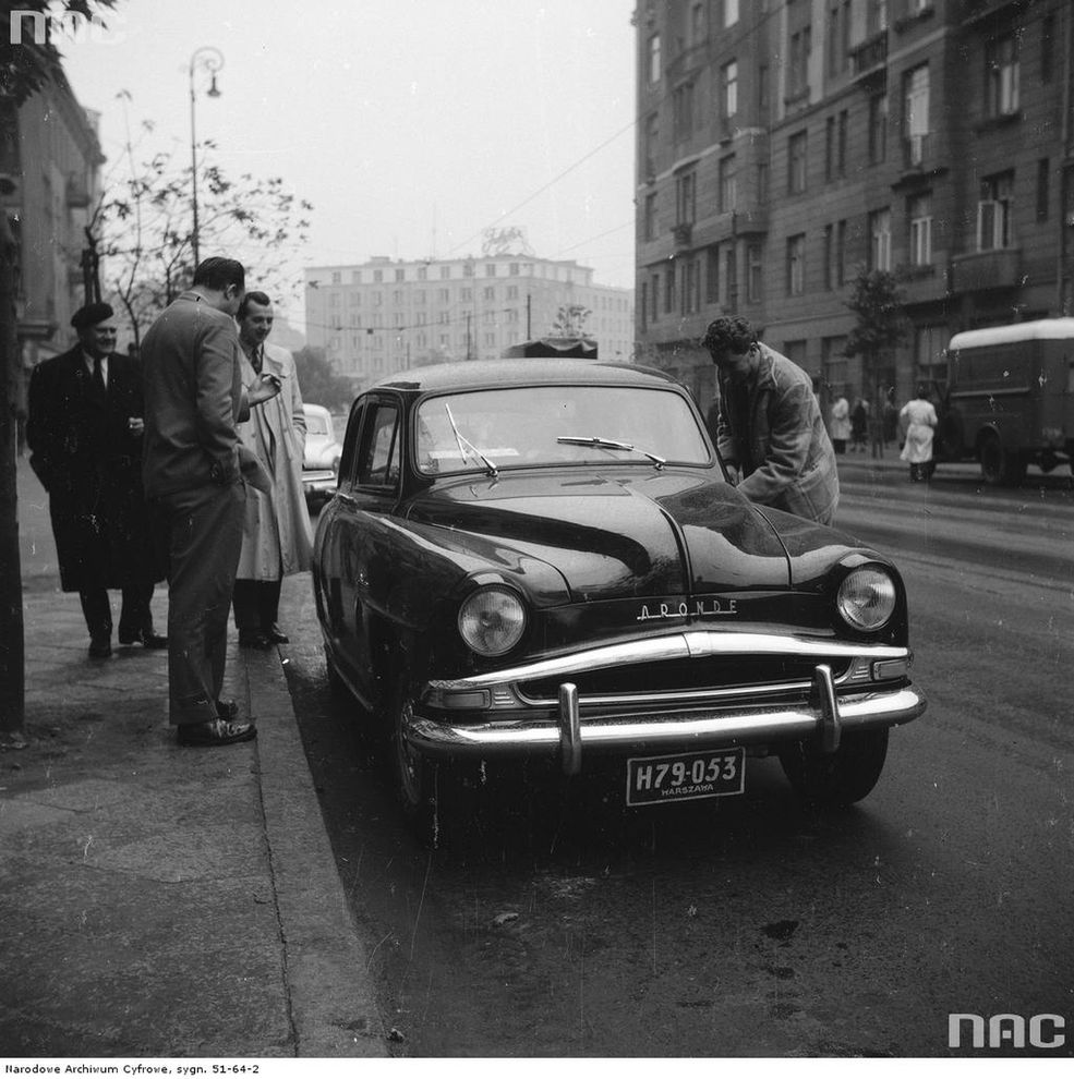Samochód osobowy Simca na ulicy Marszałkowskiej u wylotu w kierunku placu Unii Lubelskiej. Widoczni m.in.: Henryk Jurko (w jasnym płaszczu) i Zbyszko Siemaszko (stoi z prawej, przy drzwiach samochodu).
