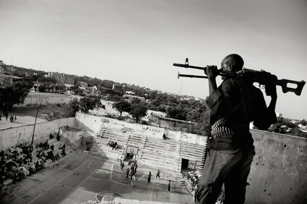 Sports Features Stories - 1 miejsce Jan Grarup sfotografował uzbrojonych ochroniarzy, nadzorujących mecz żeńskiej koszykówki w stolicy Somalii, Mogadiszu. Uprawiając sport, Somalijki ryzykują życie. 19-letnia kapitan drużyny, Suweys, mówi, że radykalni wyznawcy islamu regularnie grożą jej śmiercią.