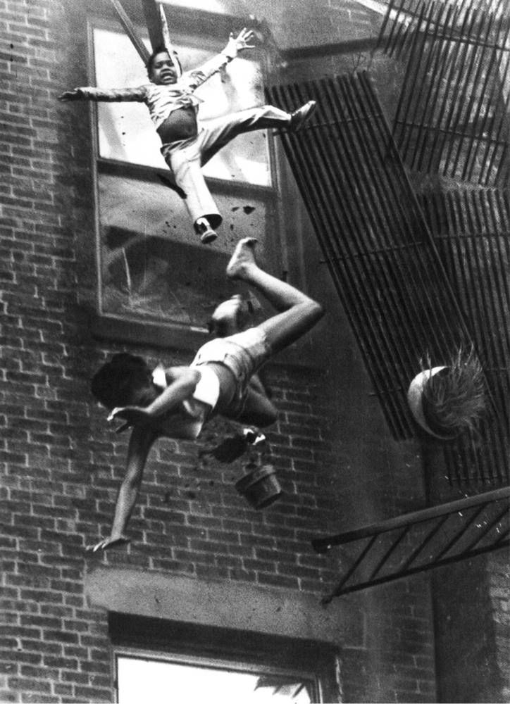 1975 r. Matka i jej córka wypadły z okna palącego się budynku. Wraz z strażakiem, czekali na drabinę i ratowników, którzy mieli do nich dotrzeć. W momencie, gdy przybyła pomoc, ogień dotarł pod nogi uciekających, którzy wypadli z okna na ziemię z wysokości 5-pięter. Kobieta zginęła, ale dziecko przeżyło - jego upadek został amortyzowany przez ciało kobiety. / Fot. Stanley Forman, World Press Photo of the Year.