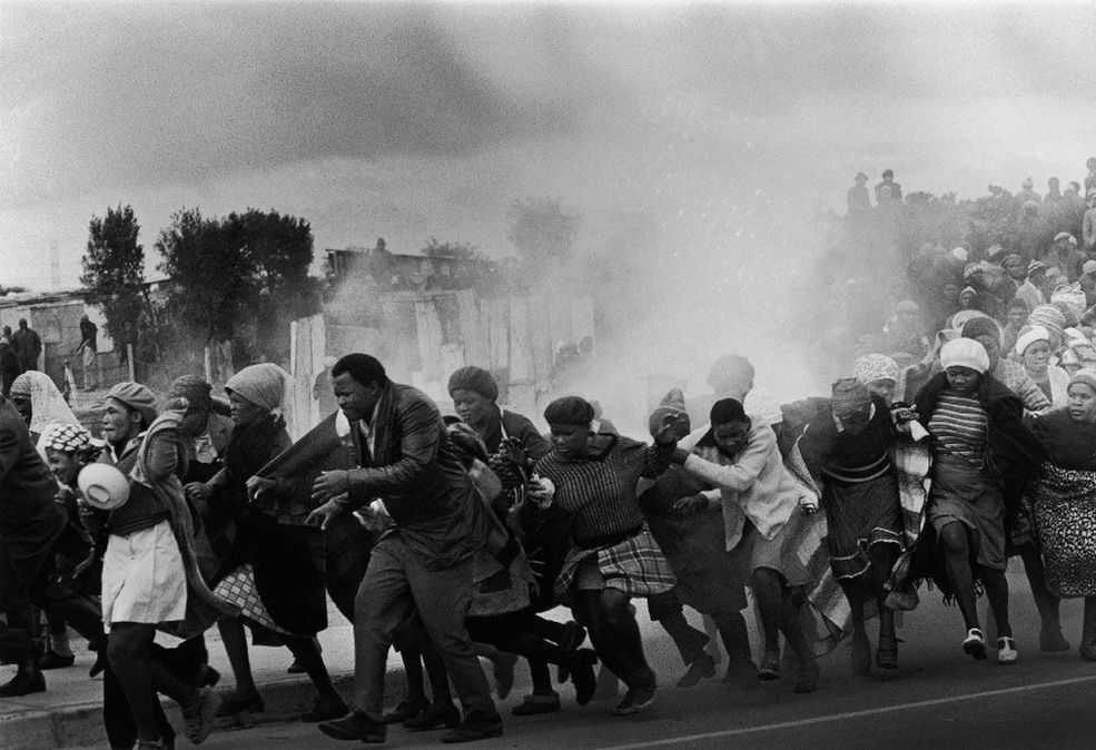 1977 r. Policja rzuca gazem łzawiącym w grupę śpiewająych mieszkańców obozu Modderdam protestująych przeciwko burzeniu domów poza Cape Town. / Fot. Leslie Hammond, World Press Photo of the Year.