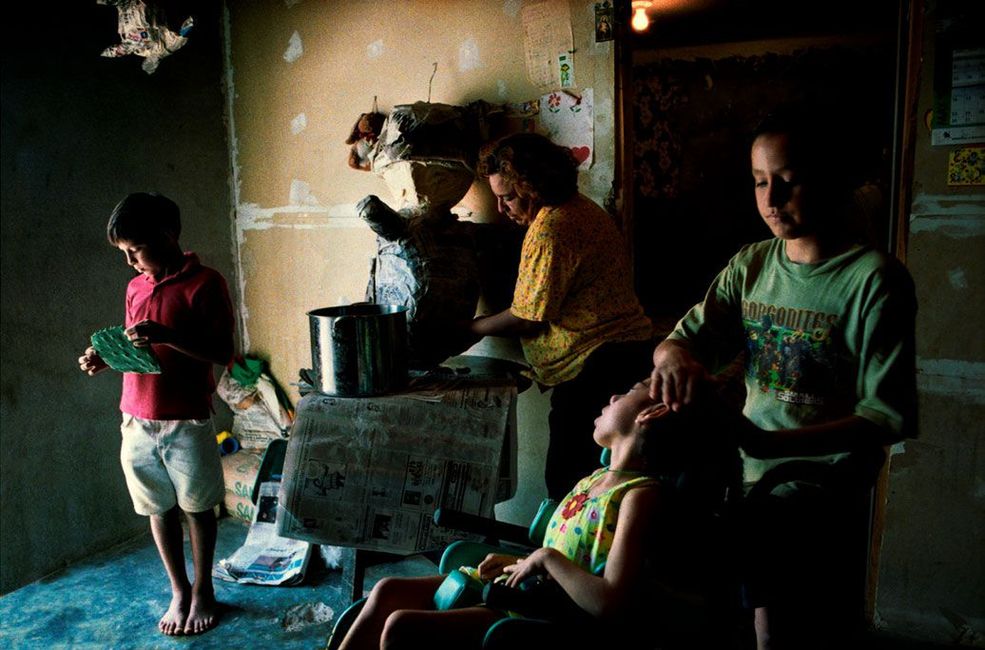 2000 r. Las Colonias, Texas, USA. Meksykańska rodzina imigrantów przygotowuje się do piñatas - ludowego zwyczaju w krajach latynoskich, osadzonego w tradycji bożonarodzeniowej. Zabawa polega na strąceniu specjalnie przygotowanej kuli, wypełnionej przeważnie słodyczami. Uczestnicy starają się zebrać ich jak najwięcej. Rodzina znalazła się wśród milionów "niepoliczonych" Amerykanów, którzy z jakiegoś powodu zostali pominięci przy narodowym spisie ludności, przez co nie istnieją w ewidencji. Wpisy decydują, gdzie powstaną nowe szkoły, szpitale czy dostępne będą podstawowe usługi socjalne.
Fot. Lara Jo Regan, World Press Photo of the Year