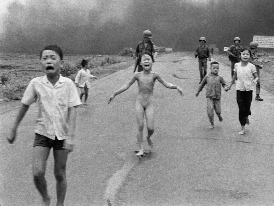 1972 r. Phan Thi Kim Phuc (w środku) ucieka z innymi dziećmi chwilę po tym, jak południowo-wietnamskie samoloty omyłkowo zrzuciły napalm na ich wioskę pełną żołnierzy i cywilów w Wietnamie Południowym. / Fot. Nick Ut, World Press Photo of the Year.