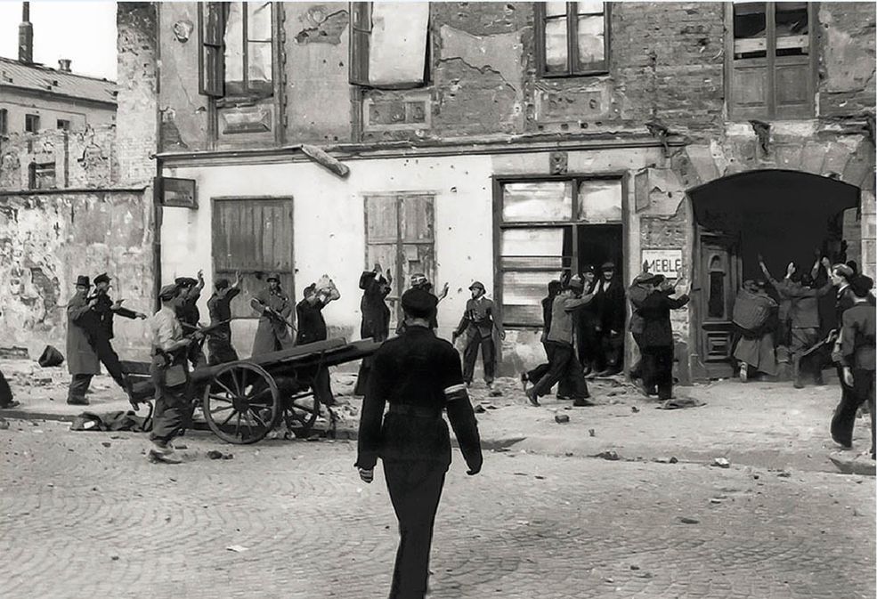 20 sierpnia. Śródmieście Północne. Jeńcy niemieccy z załogi PAST-y eskortowani przez powstańców na podwórze kamienicy przy Zielonej 34.
Eugeniusz Lokajski w Powstaniu był oficerem łącznikowym i dowódcą kompanii "Koszta". Zginął pod gruzami zbombardowanej kamienicy przy Marszałkowskiej 129.