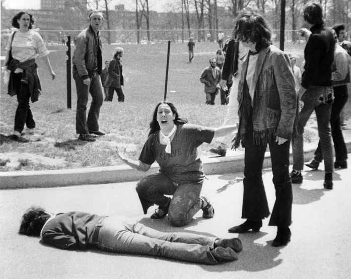 1970 rok Dobrze znane zdjęcie autorstwa Johna Filo ukazuje Mary Ann Vecchio krzyczącą na kolanach nad ciałem studenta Jeffrey'a Millera. Fotografię wykonano na Kent State University, gdzie gwardia narodowa strzelała do tłumu zabijając 4 osoby i raniąc 9. Zdjęcie zostało opublikowane w magazynie TIME, jednak pozbawiono go widocznego z tyłu płotu.
