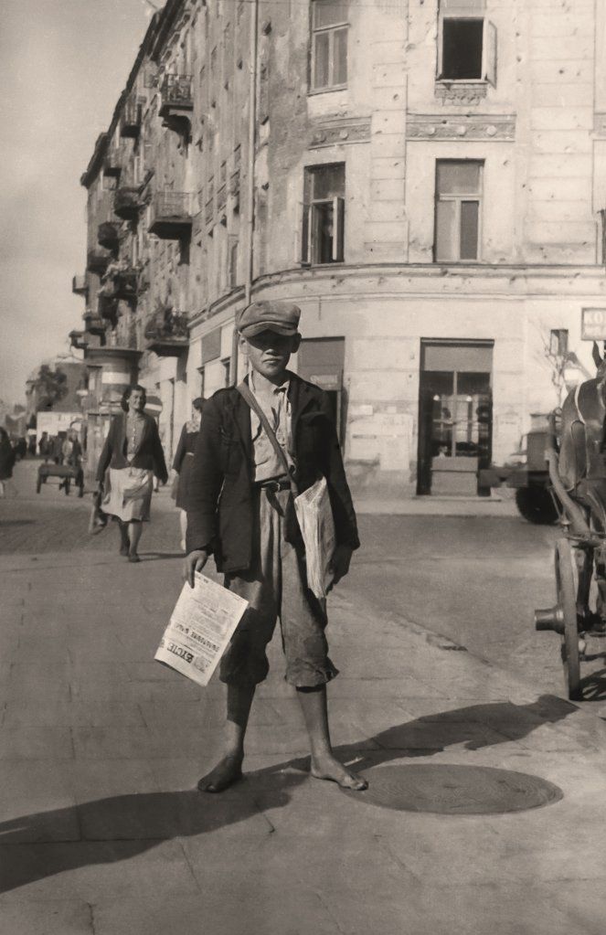 Na zdjęciu bosy gazeciarz, sprzedający "Życie Warszawy", które zaczęło się ukazywać już 15 października 1944 roku.
Autorem większości prezentowanych tu zdjęć jest Stefa Rassalski, który urodził się w 1910 roku. Kiedy około 1936 roku trafił do Warszawy pracował jako reporter i dziennikarz.