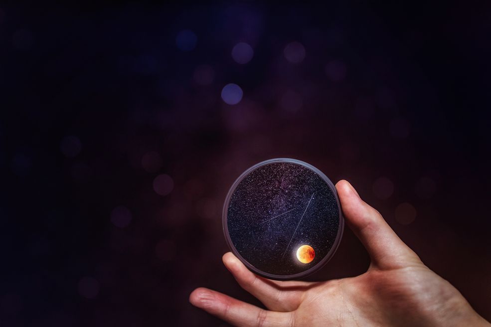 Mateusz Marzec nie planował fotografowania zaćmienia księżyca, jednak nocne niebo skusiło go swoim urokiem. Chwycił za aparat i zrobił wspaniałe zdjęcie, pomimo tego, że sądził, że nie ma odpowiedniego sprzętu.
- Podczas tegorocznego zaćmienia księżyca postanowiłem zostać w domu i odpuścić sobie fotografowanie tego zjawiska, ponieważ najdłuższa ogniskowa w obiektywach, które miałem przy sobie, wynosiła 50 mm, więc niewiele mogłem zdziałać - mówi Mateusz.
Kiedy Księżyc znalazł się w cieniu Ziemi, Mateusz zobaczył, że na niebie pojawiło się mnóstwo gwiazd, których nie byłoby widać podczas normalnej pełni. Ten widok zmotywował go do sfotografowania zaćmienia na swój własny sposób.