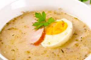 Zupa na bazie żytniego zakwasu, doprawiona czosnkiem i majerankiem, podawana z białą kiełbasą. 