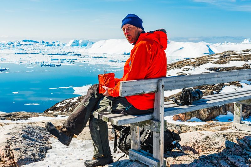 Mężczyzna odpoczywający na ławce z widokiem na lodowiec