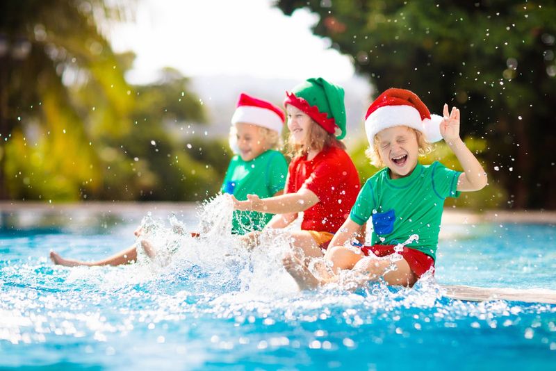 Dzieci w czapkach Mikołaj nad basenem