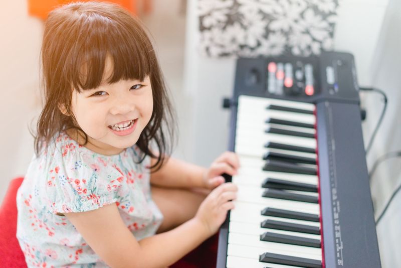 Mała dziewczynka gra na elektronicznym pianinie 