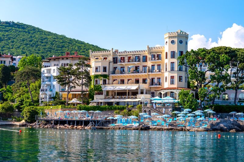 Opatija w Chorwacji od strony morza, na brzegu parasole 