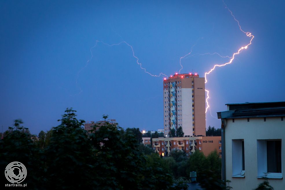 Poznańskie Rataje widok na północny wschód z 4 piętra klatki schodowej, wczesne godziny poranne tuż po wschodzie słońca. Wyładowania atmosferyczne za 16 piętrowymi wieżowcami. Canon 1D Mark IV, Canon 24-70 mm f/2.8, ISO 400, F/9 T 10 s.