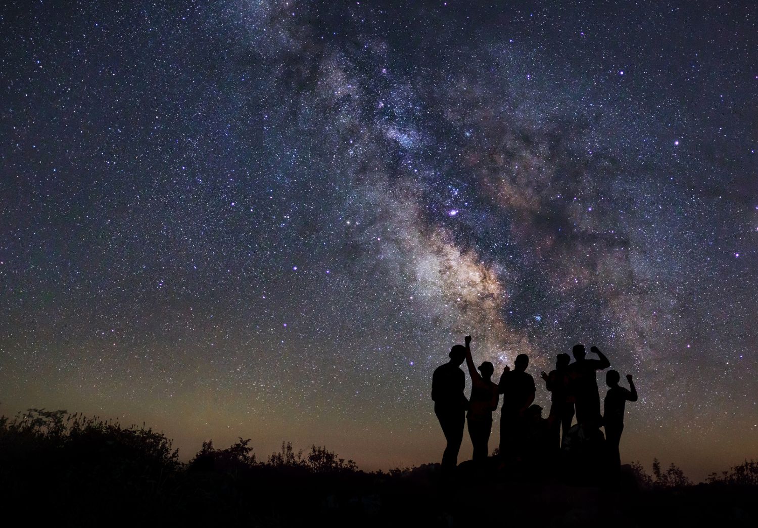 Astroturystyka - grupa przyjaciół oglądająca gwiazdy i drogę mleczną w nocy