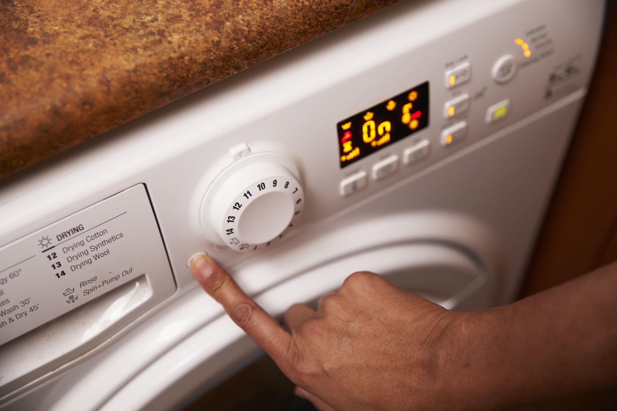 Woman operating washing machine at homeWestend6150-60 years, adults, automat, device, elevated view, female indian, home, mature adults, mature woman, united kingdom, woman, writing