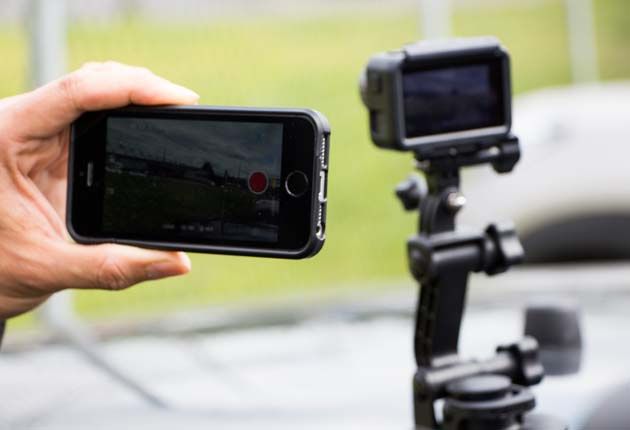 DJI Osmo Action - kamera w uchwycie samochodowym i telefon z aplikacją DJI Mimo