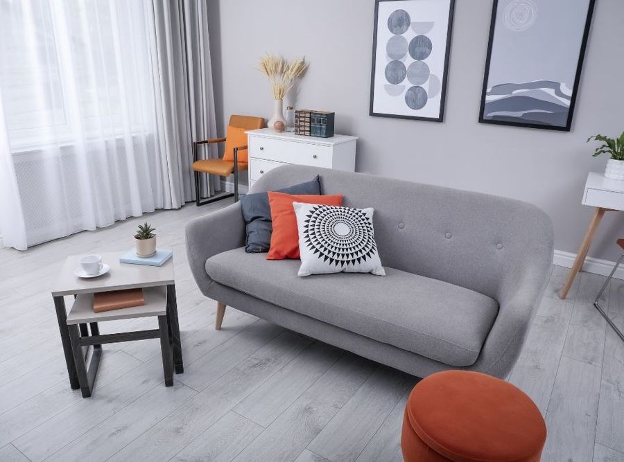 Szary salon z czerwonymi dodatkami.
