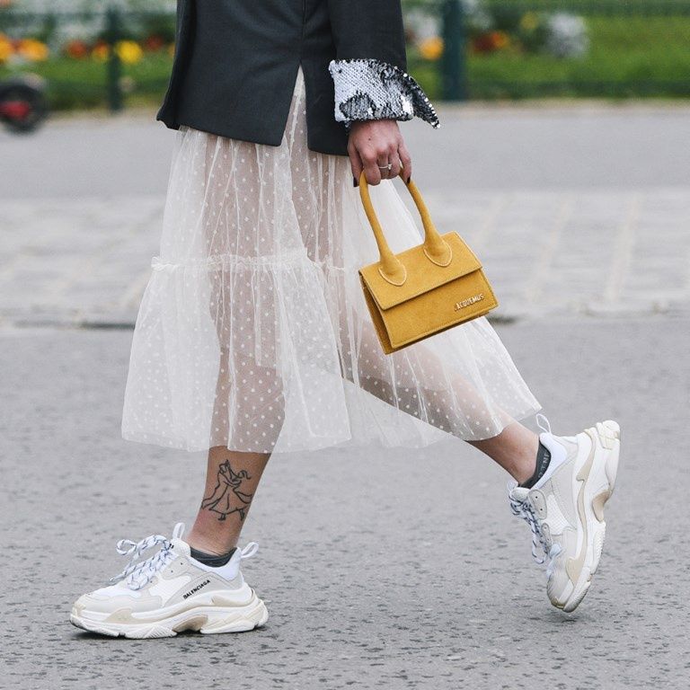 Kobieta w sukience i białych sneakersach